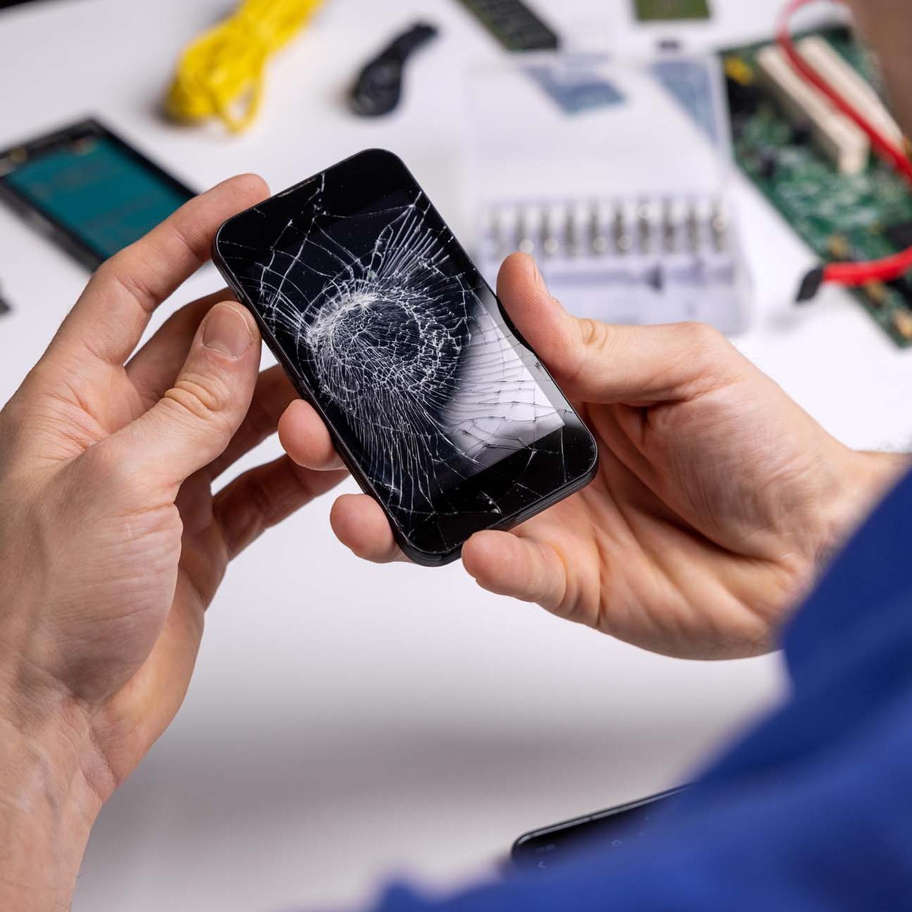 Smartphone with broken cracked screen in technician hands. phone repair service concept